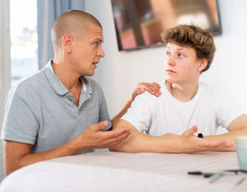 an adult talking to a teenager