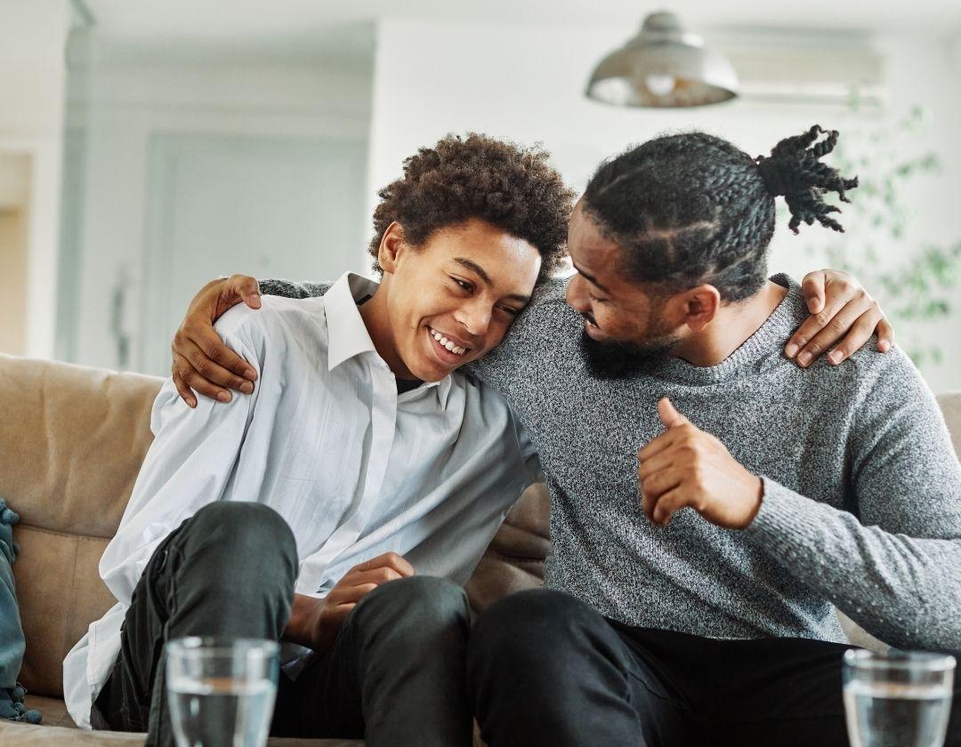 A father embracing his son while sitting next to him