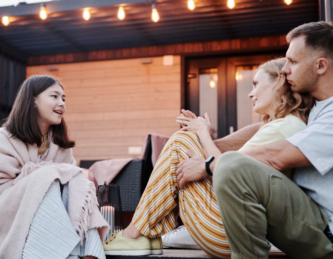A family sitting outside their home