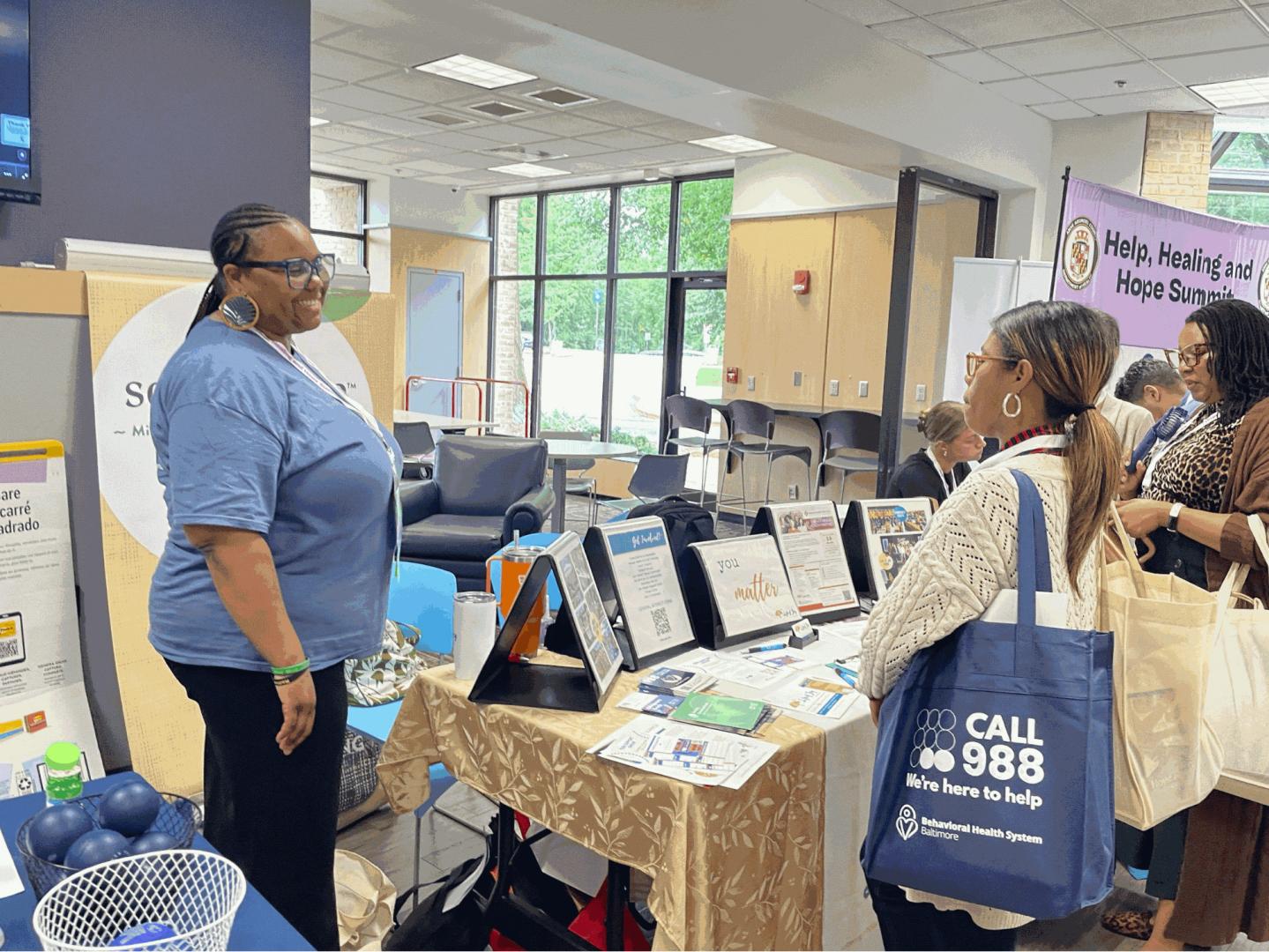 A person standing in front of a table with three people sitting behind it.