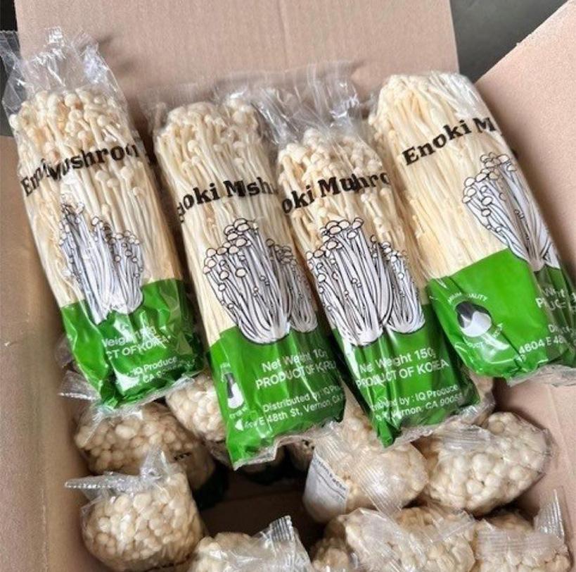 packages of Enoki mushrooms in a cardboard box