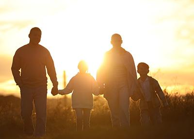Family Holding Hands in the bright Sunlight